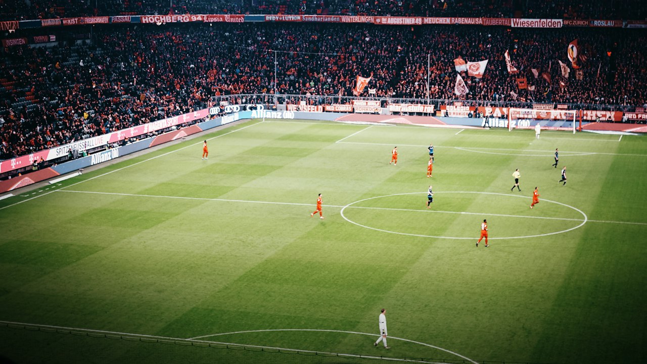Fans watching a football match in a packed stadium