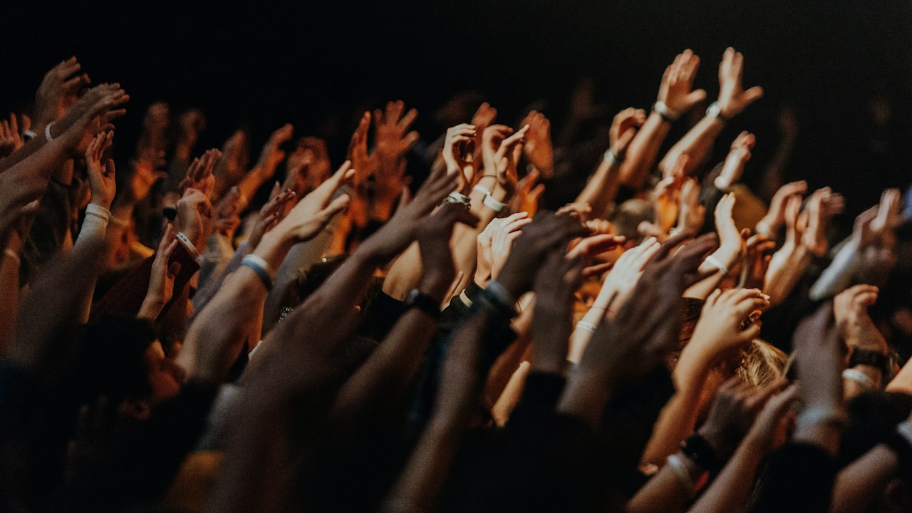 A crowd of people raising their hands